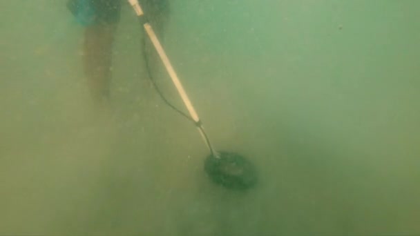 Silueta muže v moři pomocí detektoru kovů k nalezení ztracené turisty šperky — Stock video