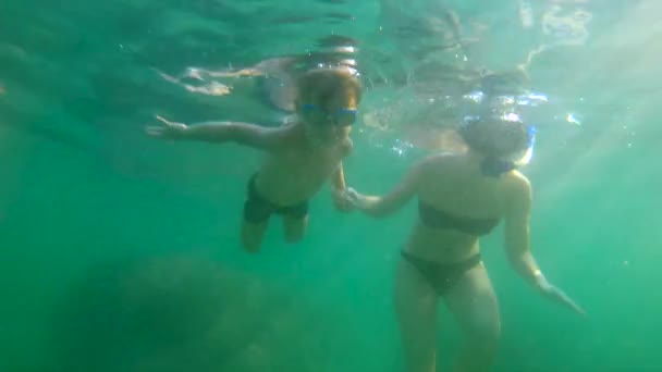 Ultraschallzeitlupe Unterwasseraufnahmen einer Frau und ihres Sohnes beim Schwitzen und Tauchen im Meer — Stockvideo