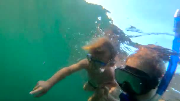 Rallentamento ultrahd colpo subacqueo di una donna e suo figlio sudare e tuffarsi in un mare — Video Stock
