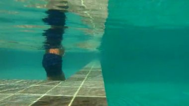 küçük bir çocuk havuza taş atan UltraHD slowmotion Sualtı çekim