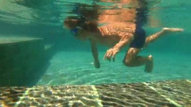 küçük bir çocuk havuza taş atan UltraHD slowmotion Sualtı çekim