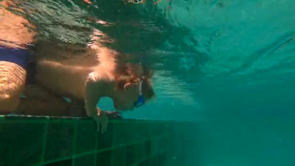 Lentidão ultrahd tiro subaquático de um menino colocando a cabeça na piscina — Vídeo de Stock