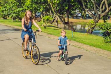 Anne ve açık havada bisiklet sürme ve gülümseyen oğlu