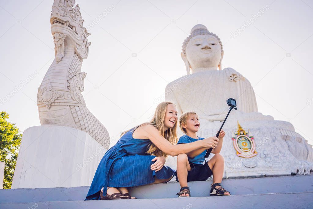 Mother and son tourists on the Big Buddha statue. Was built on a high hilltop of Phuket Thailand Can be seen from a distance. Traveling with children concept.