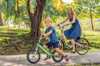 Anne ve açık havada bisiklet sürme ve gülümseyen oğlu