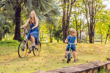 Anne ve açık havada bisiklet sürme ve gülümseyen oğlu