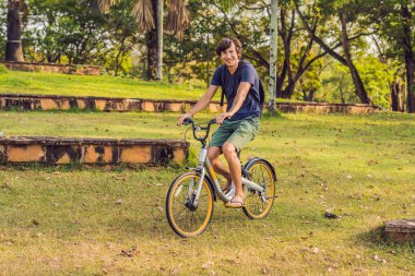 Güneşli bir günde bisiklet sürerken formda olan genç adam..
