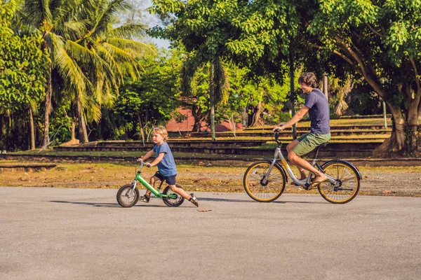 父亲和儿子骑自行车户外和微笑 — 图库照片