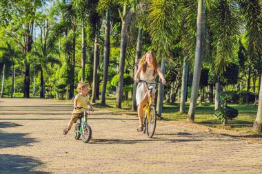 Anne ve açık havada bisiklet sürme ve gülümseyen oğlu