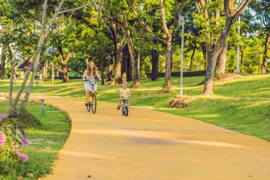 Anne ve açık havada bisiklet sürme ve gülümseyen oğlu