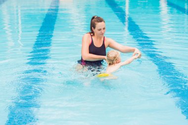 Genç anne küçük oğlu, öğretim gündüz yüzme havuzunda yüzmeyi