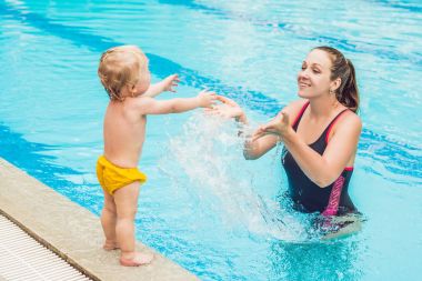 Genç anne küçük oğlu, öğretim gündüz yüzme havuzunda yüzmeyi