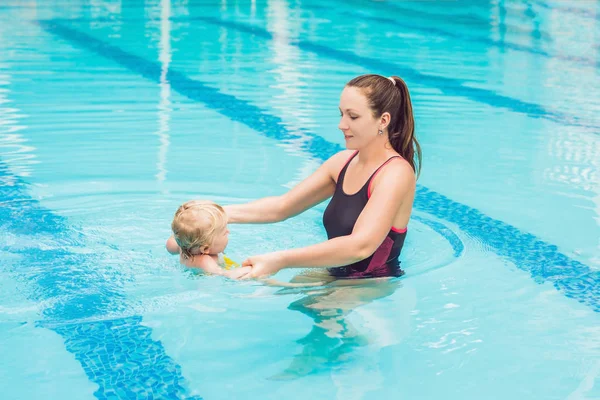 Genç anne küçük oğlu, öğretim gündüz yüzme havuzunda yüzmeyi