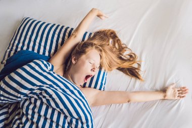 Yatakta yatarken ve uyuyan güzel ve genç birbayan. Yeterli uyku kavramı alamadım.