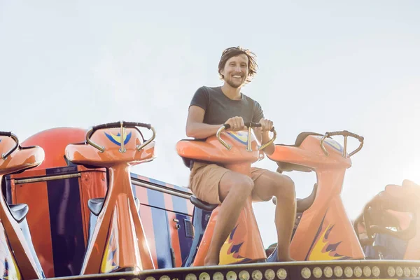 Hermoso, joven hombre divirtiéndose en un parque de atracciones — Foto de Stock