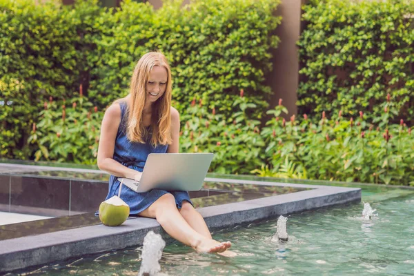 그녀의 휴대용 퍼스널 컴퓨터와 수영장 근처에 앉아있는 프리랜서 휴일에 — 스톡 사진