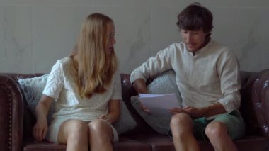 genç kadın emlakçı istemci bir apartman binası salonunda karşılamaktadır. İstemci bir sözleşme okur