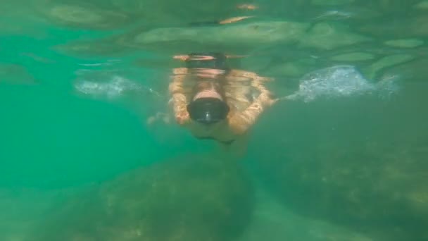 Медленный снимок молодой женщины, ныряющей с маской в море — стоковое видео