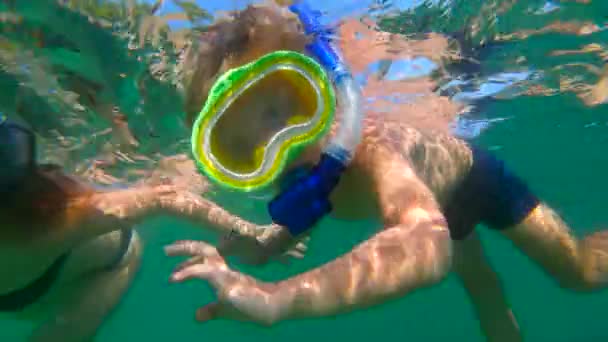 Slowmotion tiro de uma jovem mulher e seu filho pequeno snorkeling em um mar — Vídeo de Stock