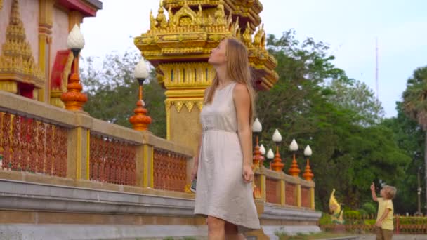 Genç kadın bir Wat Chalong Tapınağı Phuket Island, Tayland ziyaret etti. — Stok video