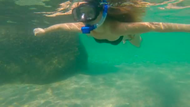 Fotografía en cámara lenta de una joven haciendo snorkel en un mar . — Vídeo de stock
