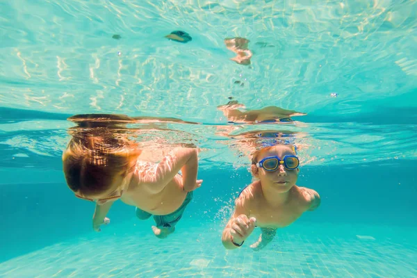 两个年轻男孩在水下泳池中潜水在白天 — 图库照片