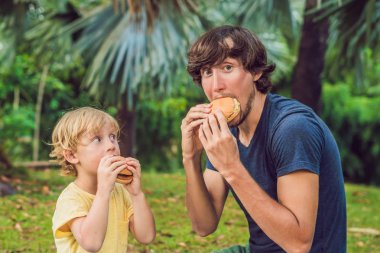 Genç Baba ve oğul hamburger parkta gündüz zevk portresi