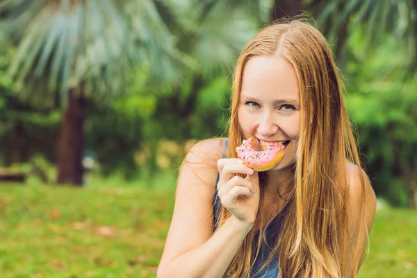 Portrait Young Woman Eating Donut Plant Background — Stock Photo, Image