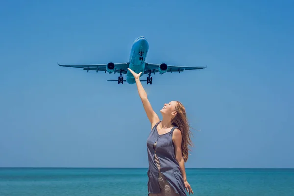 Young woman on the beach and landing planes. Travel concept.