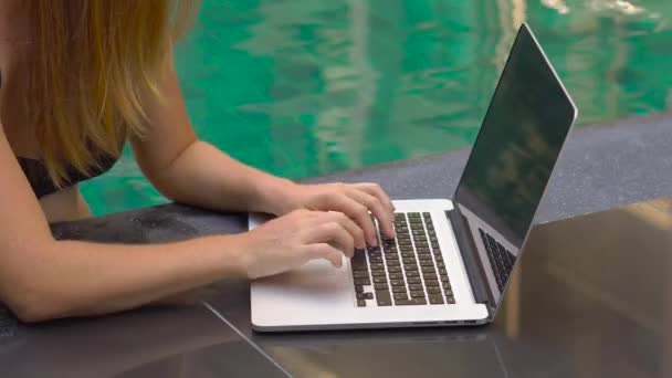 彼女のラップトップでプールのそばに座って若い女性フリーランサー 休日に忙しい 遠い仕事の概念 — ストック動画