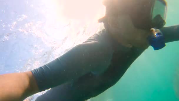 Fotografía en cámara lenta de un joven buceando y sumergiéndose en el mar. U.P.F 50 en la manga de la camisa - indica el Factor Ultravioleta de la Protección de la camisa . — Vídeos de Stock