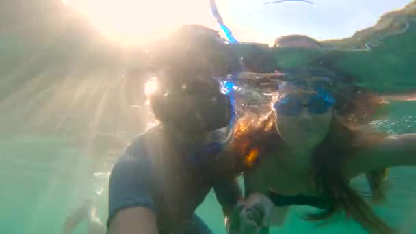 Медленная съемка молодой женщины и мужчины, плавающих с маской в тропическом море — стоковое видео