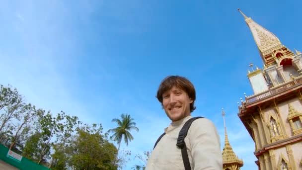 Fotografía en cámara lenta de un hombre haciendo selfie en fron de un templo budista de Wat Chalong en la isla de Phuket, Tailandia — Vídeo de stock