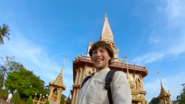 Plan au ralenti d'un homme faisant du selfie devant un temple bouddhiste Wat Chalong sur l'île de Phuket, Thaïlande — Video