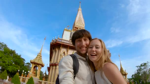Slowmotion πλάνο του μια νεαρή γυναίκα και η γυναίκα που κάνει selfie στο fron της Wat Chalong βουδιστικό ναό στο νησί Πουκέτ, Ταϊλάνδη — Αρχείο Βίντεο
