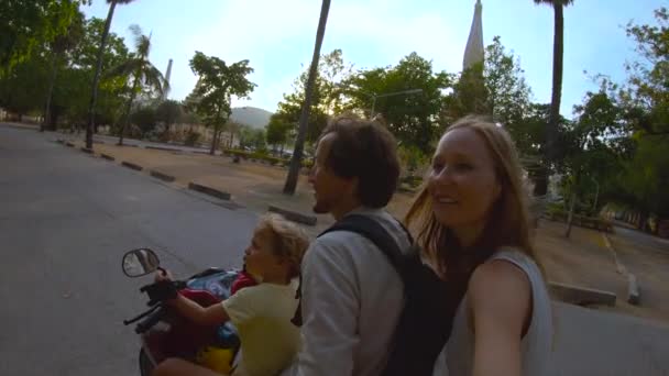 Fotografía en cámara lenta de una familia haciendo selfie en una moto frente a un templo budista de Wat Chalong en la isla de Phuket, Tailandia — Vídeos de Stock