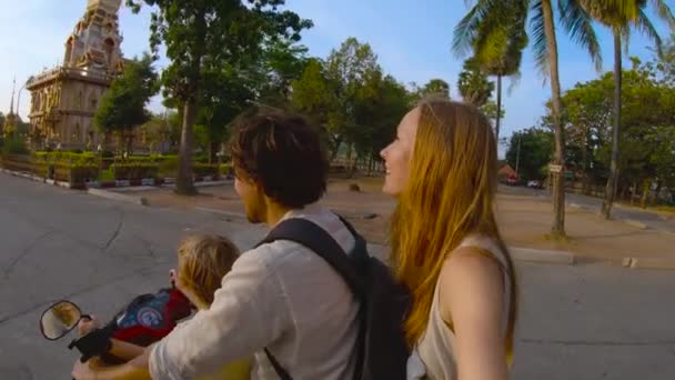 Plan ralenti d'une famille faisant du selfie à moto devant un temple bouddhiste Wat Chalong sur l'île de Phuket, Thaïlande — Video