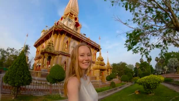 Slowmotion πλάνο του μια νεαρή γυναίκα που κάνει selfie στο fron της Wat Chalong βουδιστικό ναό στο νησί Πουκέτ, Ταϊλάνδη — Αρχείο Βίντεο