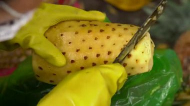 Kişi bir piyasada bir ananas soyma.