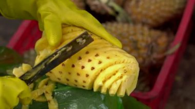 Kişi bir piyasada bir ananas soyma.