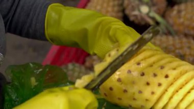 Kişi bir piyasada bir ananas soyma.