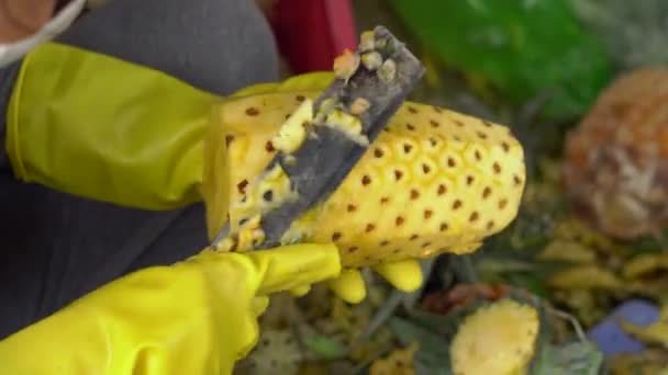 Persoon peel een ananas op een markt. — Stockvideo