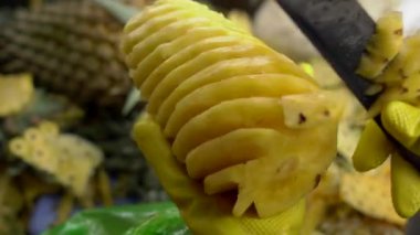 Kişi bir piyasada bir ananas soyma.