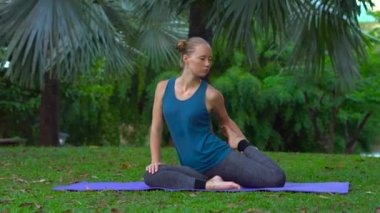 genç kadının tropikal bir parkta yoga egzersizleri yapması