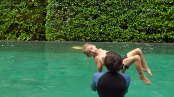 Инструктор Мужчина Обучает Мальчика Плаванию Бассейне Днем — стоковое видео