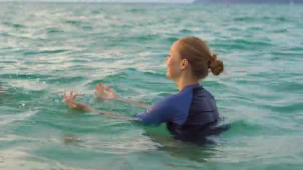 女性水泳インストラクター少年、sundet の間に海で泳ぎを教えています。 — ストック動画