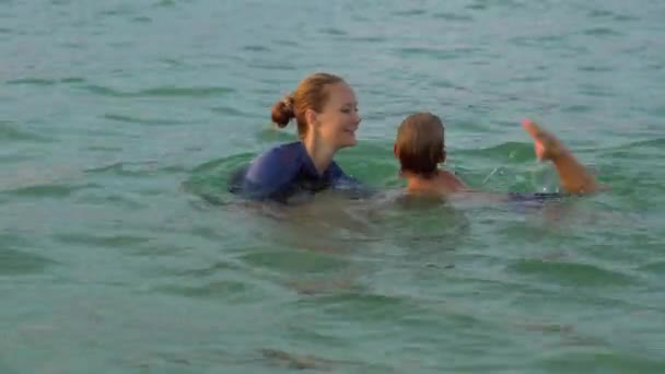 여자 수영 강사는 sundet 동안 바다에 수영 하는 어린 소년을가 르 친다 — 비디오