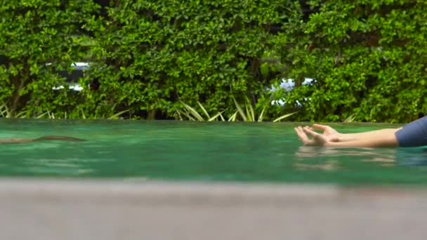 Ung kvinna simlärare lära småbarn pojke att simma i en pool — Stockvideo