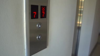 adam bir asansör ara ve içine girmek için düğmeye bas