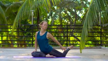 genç kadının tropikal bir parkta yoga egzersizleri yapması